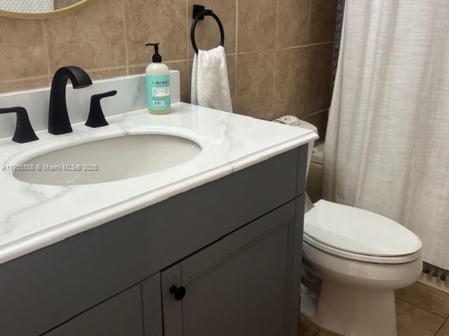 bathroom with tile patterned floors, tile walls, vanity, and a shower with curtain