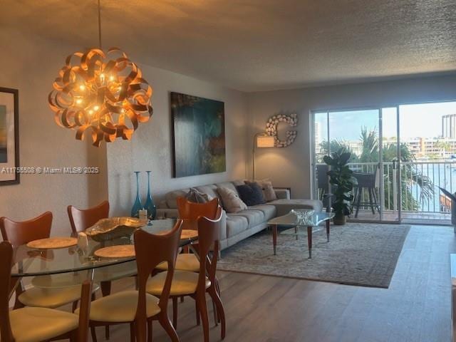 dining room featuring wood finished floors, a textured ceiling, and a chandelier
