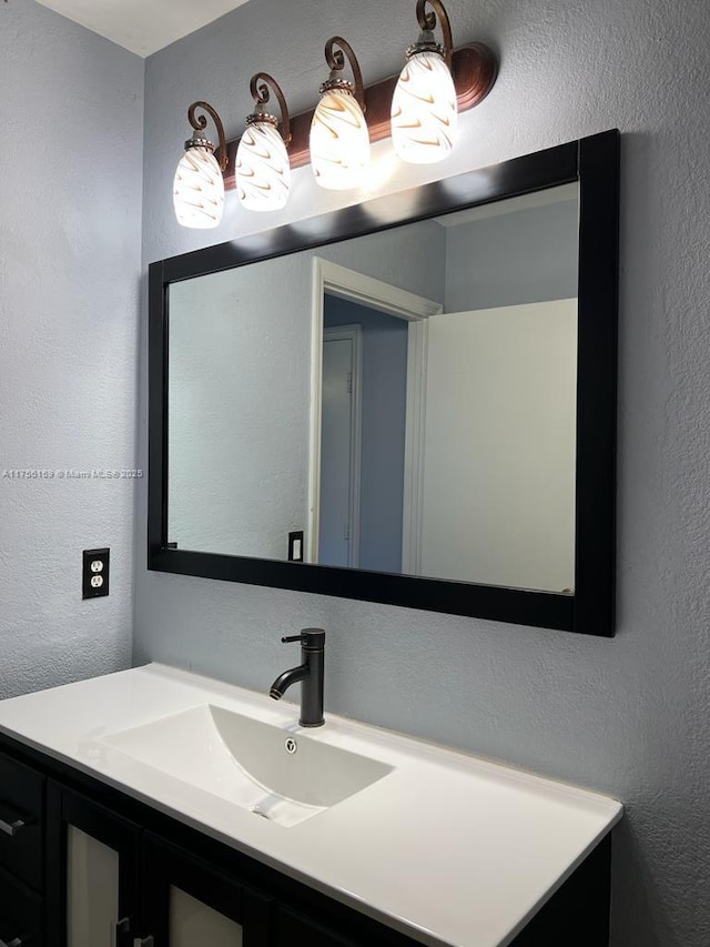 bathroom featuring a textured wall and vanity