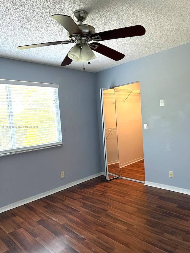 unfurnished bedroom with baseboards, a ceiling fan, wood finished floors, a textured ceiling, and a closet