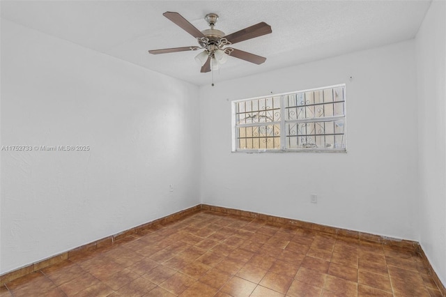 unfurnished room featuring a ceiling fan and baseboards