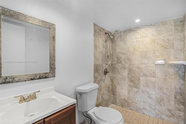 full bathroom with toilet, tiled shower, and vanity