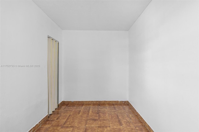 spare room featuring baseboards