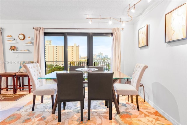 tiled dining area with crown molding, a view of city, baseboards, and a textured ceiling