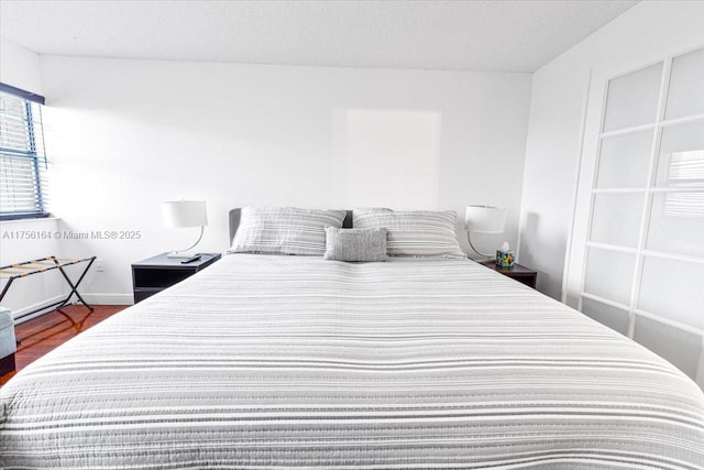 bedroom featuring a textured ceiling and wood finished floors