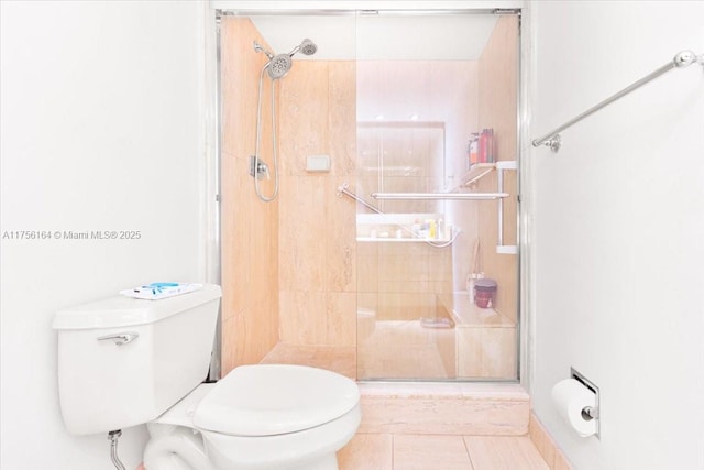 full bath with tile patterned floors, a stall shower, and toilet