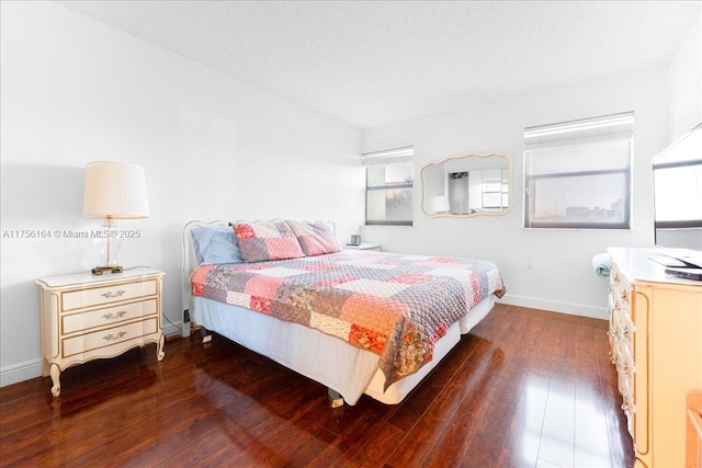 bedroom featuring hardwood / wood-style flooring, baseboards, and a textured ceiling