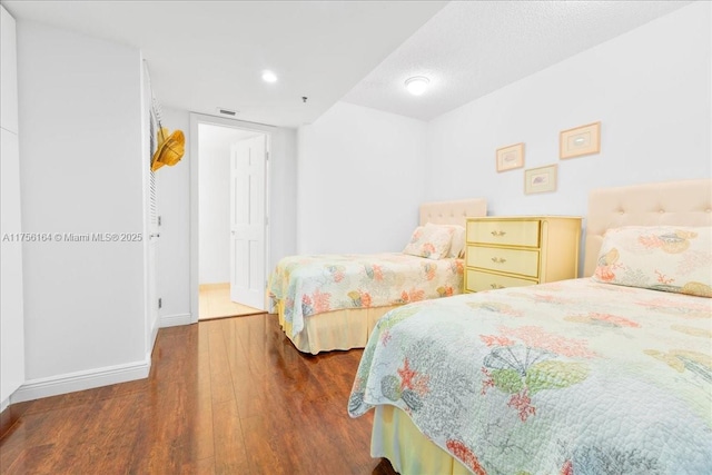 bedroom featuring visible vents, baseboards, and wood finished floors