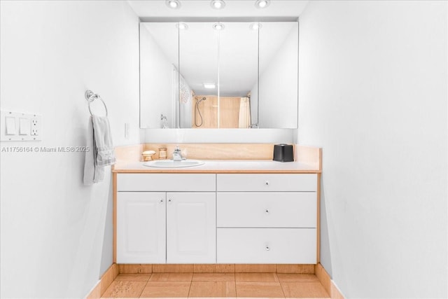 full bathroom featuring tile patterned floors, vanity, baseboards, and a shower with curtain