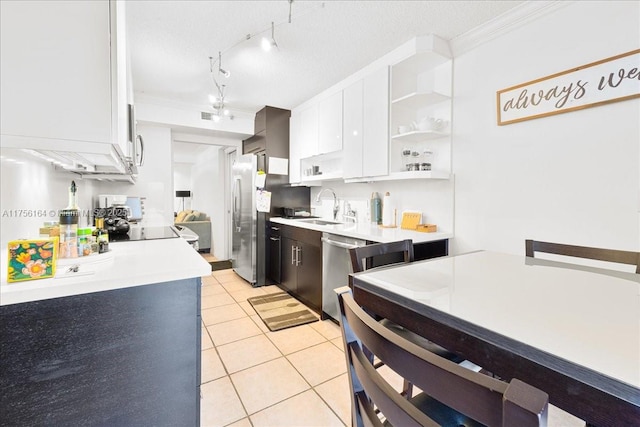 kitchen with a sink, white cabinetry, stainless steel appliances, light countertops, and light tile patterned floors