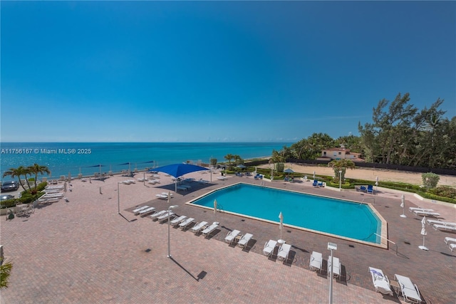 community pool featuring a water view and a patio