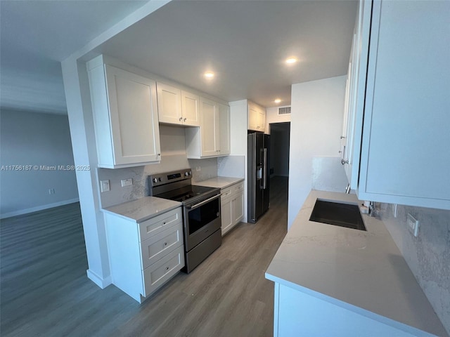 kitchen featuring stainless steel range with electric stovetop, light wood-style floors, white cabinetry, and black fridge with ice dispenser