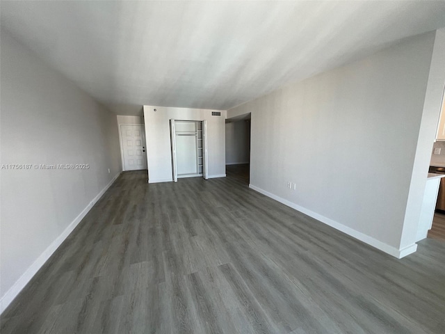 unfurnished bedroom featuring visible vents, baseboards, and dark wood-type flooring