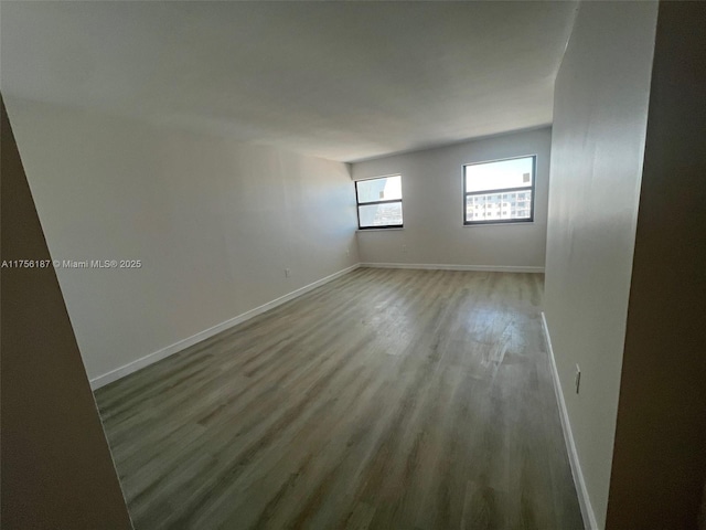 unfurnished room featuring baseboards and wood finished floors