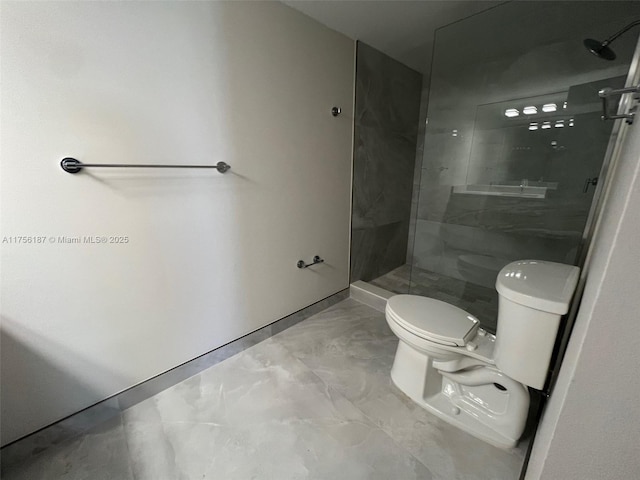 full bathroom featuring toilet, marble finish floor, and a walk in shower