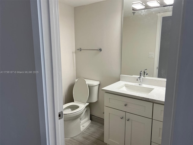 bathroom featuring vanity, toilet, and wood finished floors