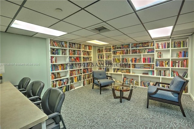 office area featuring carpet floors, visible vents, and bookshelves