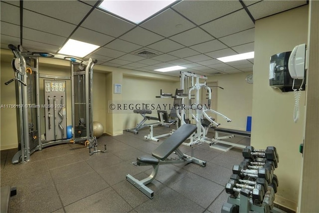 gym with a drop ceiling, visible vents, and baseboards