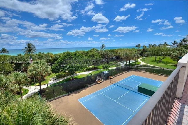 view of sport court with a water view and fence