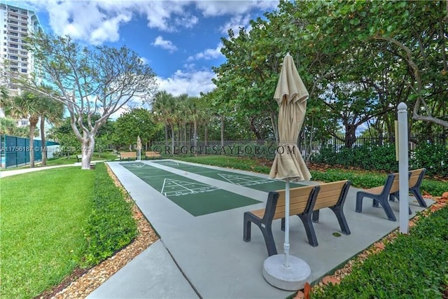 view of home's community featuring fence, shuffleboard, and a lawn