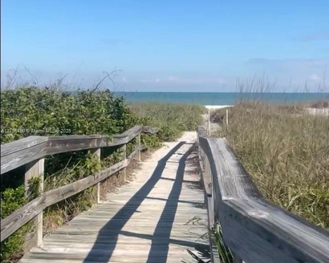 surrounding community featuring a water view and a beach view