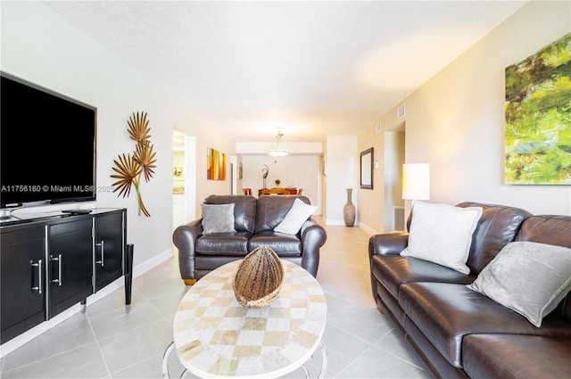 living area featuring light tile patterned flooring, visible vents, and baseboards