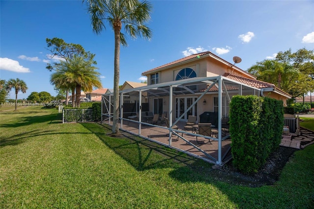 7800 NW 29th St, Margate, FL 33063 - rear view of house with glass enclosure, a lawn, stucco siding, and a patio area