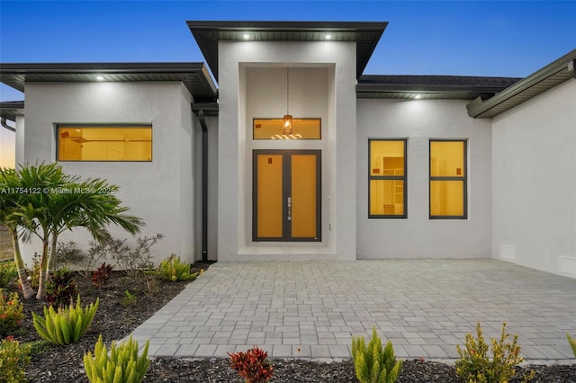 entrance to property featuring stucco siding