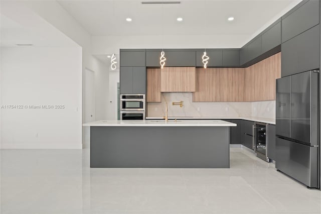 kitchen featuring modern cabinets, appliances with stainless steel finishes, light countertops, and backsplash