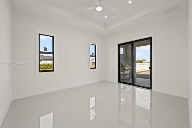 empty room featuring baseboards, visible vents, a raised ceiling, a ceiling fan, and recessed lighting