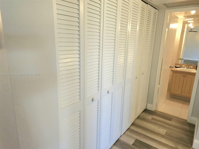corridor featuring wood finished floors and a sink