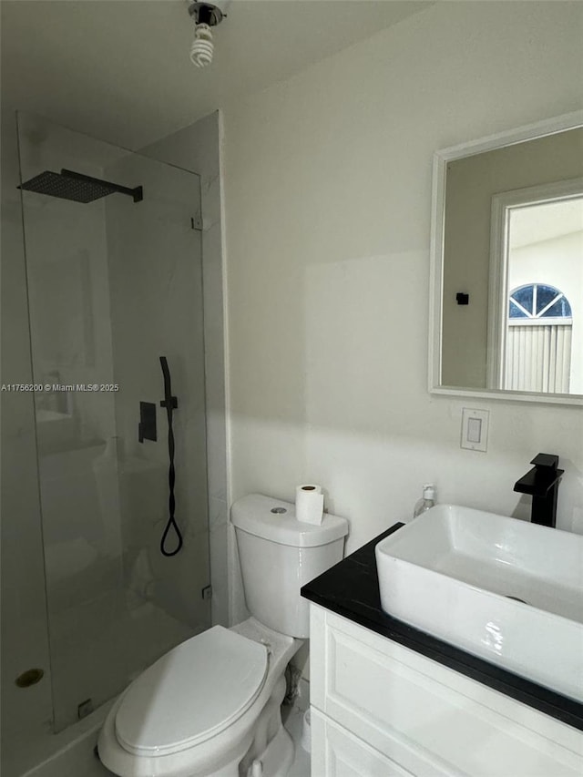 full bath with a stall shower, vanity, and toilet