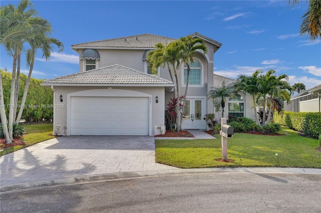 view of front of home featuring a garage, french doors, a tiled roof, and a front lawn