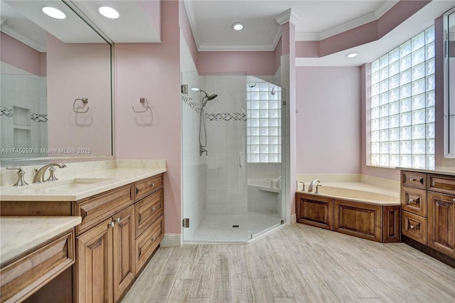 bathroom featuring a garden tub, a shower stall, crown molding, and vanity