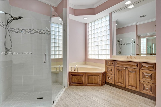 full bath with visible vents, ornamental molding, a garden tub, vanity, and a shower stall