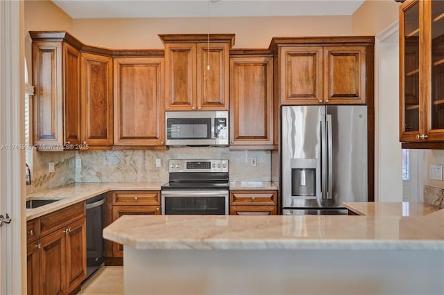 kitchen with appliances with stainless steel finishes, brown cabinetry, and decorative backsplash