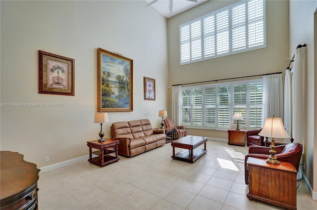 living area with baseboards, a high ceiling, and tile patterned floors