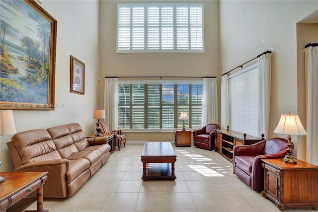 living area with a towering ceiling and light tile patterned floors