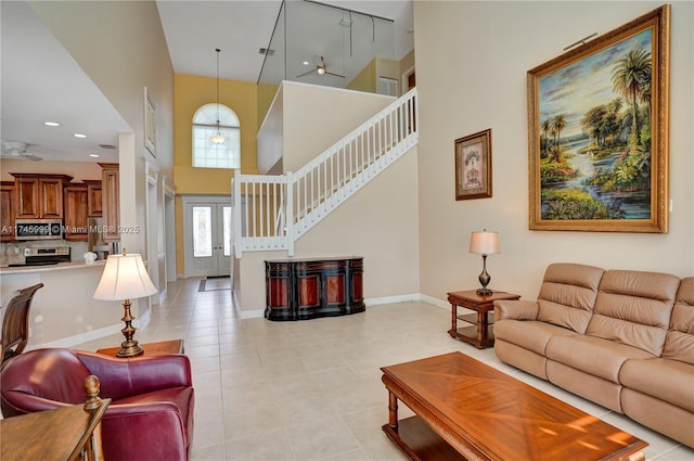 living room with light tile patterned floors, baseboards, a towering ceiling, stairs, and recessed lighting