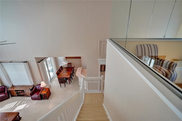 stairway with a towering ceiling and wood finished floors