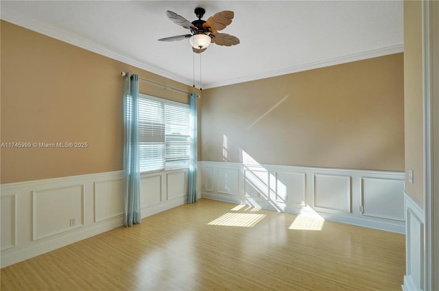 spare room featuring crown molding, light wood finished floors, and ceiling fan