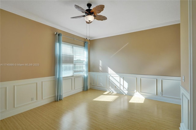 empty room featuring light wood-type flooring, ceiling fan, and ornamental molding