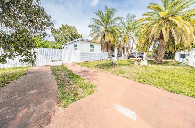 exterior space with a gate, a front lawn, and fence