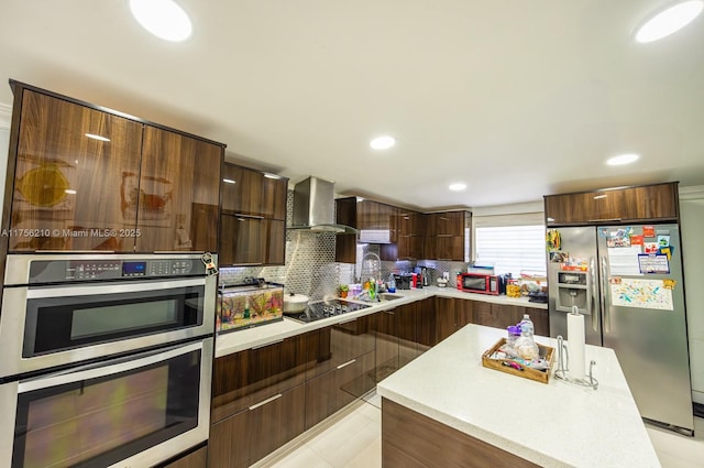 kitchen featuring stainless steel appliances, modern cabinets, light countertops, and wall chimney range hood