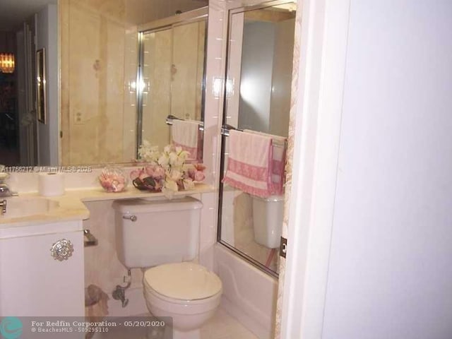 full bathroom with shower / bath combination with glass door, vanity, and toilet