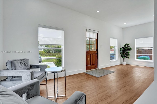 foyer featuring baseboards, wood finished floors, and recessed lighting