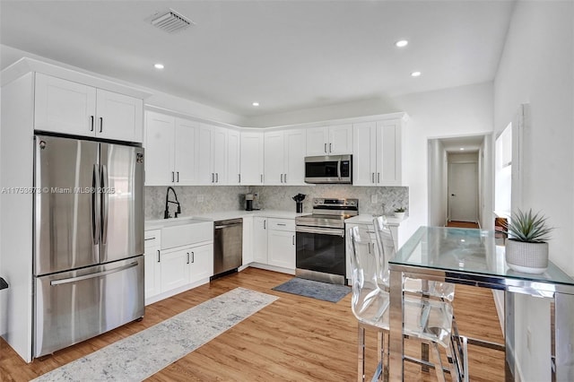 kitchen featuring white cabinetry, visible vents, tasteful backsplash, and appliances with stainless steel finishes