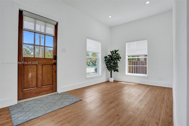 foyer featuring baseboards, wood finished floors, and recessed lighting