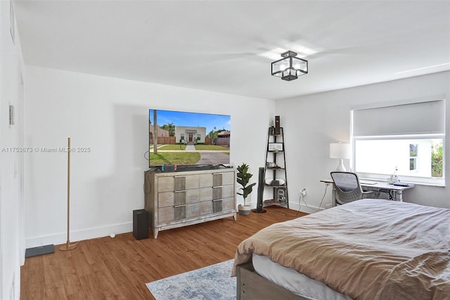 bedroom with baseboards and wood finished floors
