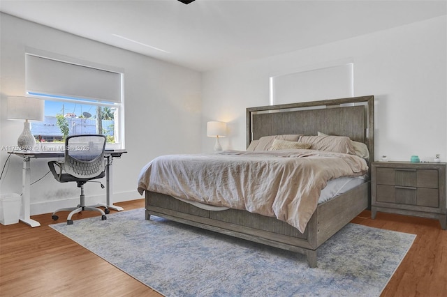 bedroom featuring baseboards and wood finished floors